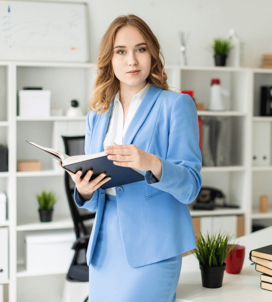 Businesswoman in a blue suit holding an open notebook in an office, photo card in the Advanced Slider Layout 6 demo